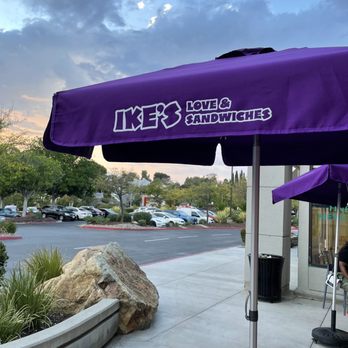 Ike's Love & Sandwiches - Outside: branded umbrellas next to the tables set up in front of the shop - Sandwiches Near Me - Poway, California Ike's Love & Sandwiches - Outside: branded umbrellas next to the tables set up in front of the shop - Sandwiches Near Me - Poway, California