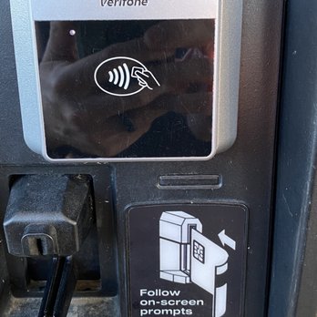 Texaco - a person taking a picture of a pay phone - Gas Stations Near Me - Ashville, Alabama