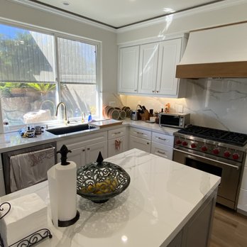 Cartage Flooring - Custom Kitchen Cabinet: Gray Color Island with White Cabinets else where.White Oak Shelves, Carrara Look porcelain Counter top. - Countertop Installation Near Me - Fullerton, California Cartage Flooring - Custom Kitchen Cabinet: Gray Color Island with White Cabinets else where.White Oak Shelves, Carrara Look porcelain Counter top. - Countertop Installation Near Me - Fullerton, California