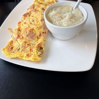 Wake Up & Eat - Farmers Omelet. Stuffed nicely with ham, tomatoes, potatoes, and cheese. Accompanied by a bowl of buttery grits. Very satisfying. - Breakfast & Brunch Near Me - Concord, North Carolina Wake Up & Eat - Farmers Omelet. Stuffed nicely with ham, tomatoes, potatoes, and cheese. Accompanied by a bowl of buttery grits. Very satisfying. - Breakfast & Brunch Near Me - Concord, North Carolina