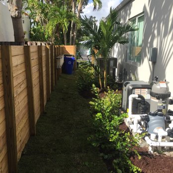 Garmizos - a back yard with a fence and a water pump - Landscaping Near Me - Davie, Florida
