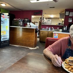 Tio's Backporch Restaurant - Cashier and kitchen behind. ( husband chowing down on his burger).