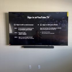 Simplistic Ent - 85 inch TV mounted along with a soundbar.