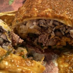 Fresh-Mex & Co - Smothered burrito close up: added onions and peppers, protein is steak.