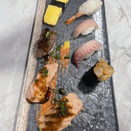 Clockwise from top right. Sweet shrimp, yellowtail, red snapper, spicy scallops, sizzle sushi, seared salmon, wagyu, tamago.
