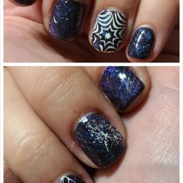 Black gel base, Space Kitty magnetic gel, stamp - The image shows a set of manicured nails with galaxy-themed glitter polish that includes dark shades with multicolored sparkles. Some nails feature black and white geometric patterns, such as starburst and spiral designs, while others display nature-inspired motifs like a butterfly and a tree. The nails are well-groomed and decorated with detailed nail art, likely created at a professional nail salon.