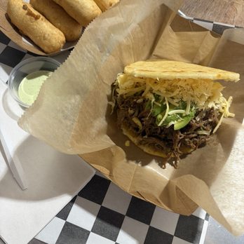 Carupano Kitchen - La Pelúa Arepa (Shredded Beef & Gouda) with avocado and a side of Tequeños - Venezuelan Near Me - St. Petersburg, Florida Carupano Kitchen - La Pelúa Arepa (Shredded Beef & Gouda) with avocado and a side of Tequeños - Venezuelan Near Me - St. Petersburg, Florida