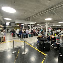 Thrifty Car Rental - Not nearly every pissed off customer fits in this wide angle photo. They are lying on top of their suitcases on the floor in the entrance.