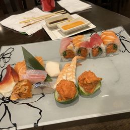 Assorted sashimi and Kamikaze Roll - A plate of assorted sushi and sashimi, including rolls, nigiri, and garnishes, served on a decorative square dish.