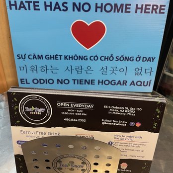 Tea Snow - "Hate Has No Home Here" - sign placed next to a stack of menu #StopAAPiHate - Coffee & Tea Near Me - Mesa, Arizona