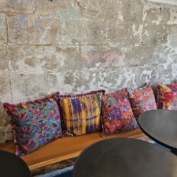 Cafecito Social - Inside seating, with colorful and beautifully embroidered pillows - Coffee & Tea Near Me - Brooklyn, New York