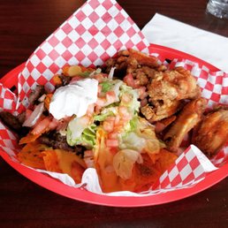 PBG Nightlife which is a plate with fried chicken wings drizzled in hot sauce and nachos made from Doritos chips PBG Nightlife which is a plate with fried chicken wings drizzled in hot sauce and nachos made from Doritos chips