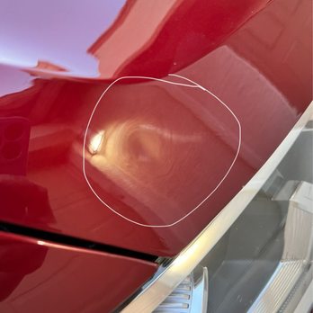 The Rustic Wrench - This doesn't make any sense. - Close-up of a red, shiny surface with a swirl pattern and a white line encircling the area, possibly part of a vehicle or appliance. - Auto Repair Near Me - Apache Junction, Arizona