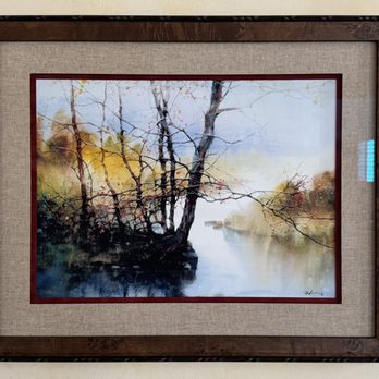 Total Framing - A watercolor painting of trees along a riverbank, framed with a wooden border and beige matting, hanging on a wall. - Framing Near Me - Chantilly, Virginia