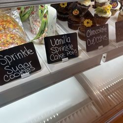 Emy Delights & Bites - Display case with cookies, cake pops and cupcakes