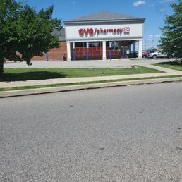 the front of the store - Exterior view of a CVS Pharmacy store with a parking lot, trees, and a clear blue sky.