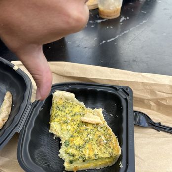 Bodega Delicatessen - a person taking a piece of food out of a plastic container - Delis Near Me - Oxford, Ohio
