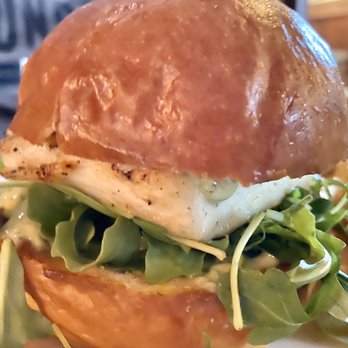 Virginia Inn - Halibut Sandwich: Grilled with arugula, pesto mayo, on a Macrina bun and house-made chips on the side... - Bars Near Me - Seattle, Washington