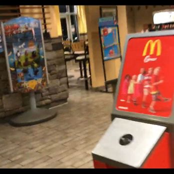 McDonald's - a man standing in front of a mcdonald's sign - Burgers Near Me - Irvington, Alabama