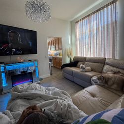 Entertainment room featuring a large TV, power reclining chairs, and a beautiful electric fireplace for comfort, relaxation, and enjoyment.