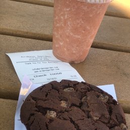 a chocolate cookie and a drink a chocolate cookie and a drink
