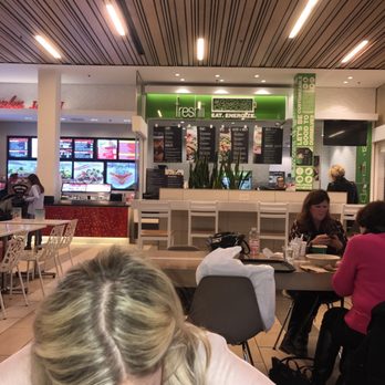 Freshii - a woman sitting at a table in a fast food restaurant - Salad Near Me - Lombard, Illinois