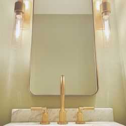 Pro Install Services - Newly installed powder room vanity with brushed gold faucet, a mirror, and 2 new wall sconce light fixtures installed in Kennett Square, Pa