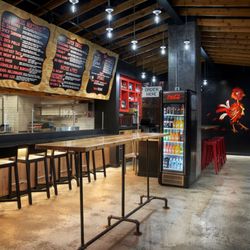 Taco Bamba Ballston - Interior of Taco Bamba Ballston with large mural featuring a red rooster, seating, bar seating, and high top seating.