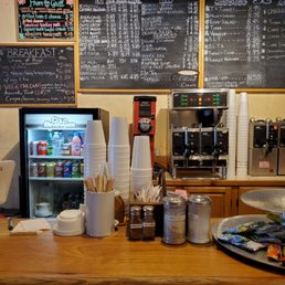 a coffee shop counter with a variety of drinks a coffee shop counter with a variety of drinks