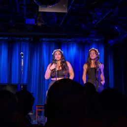 two women singing on stage two women singing on stage