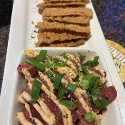 Tuna tartare over guacamole served with fried wonton wrappers Tuna tartare over guacamole served with fried wonton wrappers