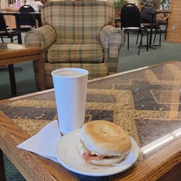 a table with a sandwich and a cup of coffee a table with a sandwich and a cup of coffee