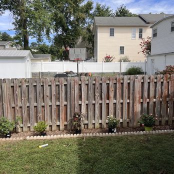 Green Smart - a backyard with a fence and flowers - Landscaping Near Me