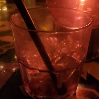 Akbar - a glass of water and a candle on a table - Gay Bars Near Me - Los Angeles, California