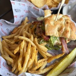 Chicken Bacon Avocado Sandwich - A chicken bacon avocado sandwich with French fries and a pickle spear on a tray at Bubba's 33 in Tempe, AZ.