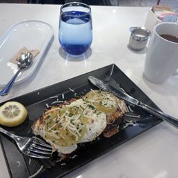 Over easy egg on top of crab cakes served on sourdough toast, with drop coffee.