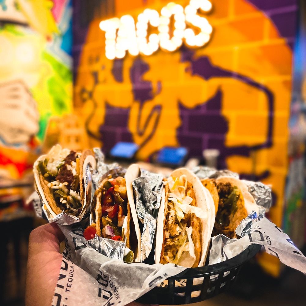 Condado Tacos - a hand holding a taco - Tacos Near Me - Carmel, Indiana