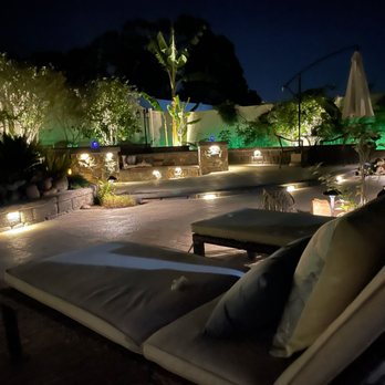 Sunlight Landscaping - a patio area with lounge chairs and lights - Landscaping Near Me