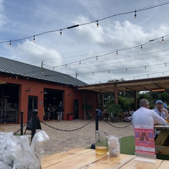Intruck Coastal Bites - a woman sitting at a picnic table - Food Trucks Near Me - Melbourne, Florida