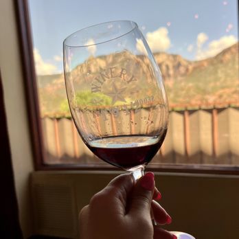Winery 1912 - a hand holding a glass of red wine - Wineries Near Me - Sedona, Arizona Winery 1912 - a hand holding a glass of red wine - Wineries Near Me - Sedona, Arizona