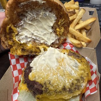Small Cheval- Hyde Park - Signature Double Cheeseburger - A cheeseburger with melted cheese, lettuce, and a toasted bun, served with French fries in a cardboard tray lined with checkered paper. - Burgers Near Me - Chicago, Illinois