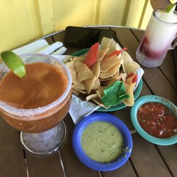 a table with chips, salsa, and a drink a table with chips, salsa, and a drink