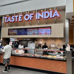 Taste of India - Taste of India counter with the menu behind.