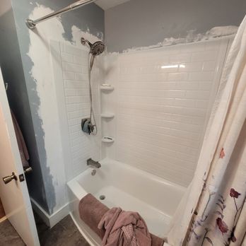 Arrow Home Improvement - a bathtub and shower in a bathroom - Plumbing Near Me Arrow Home Improvement - a bathtub and shower in a bathroom - Plumbing Near Me