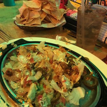 Flanigan's - Giant pile of nachos in background. The dish, tbs of sourcream, guacamole, sliced jalapenos a tbs of cheese to glue together. - Seafood Near Me - Stuart, Florida
