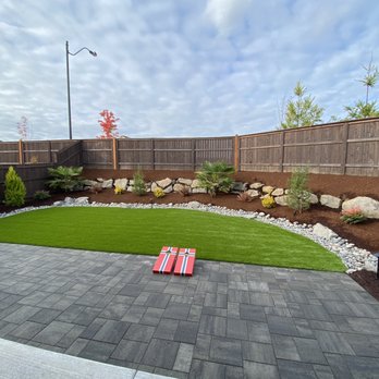 Luong's Landscaping - Clean and simple backyard. Artificial grass with patio. Palm trees, mountain hemlock, various shrubs. - Landscaping Near Me Luong's Landscaping - Clean and simple backyard. Artificial grass with patio. Palm trees, mountain hemlock, various shrubs. - Landscaping Near Me