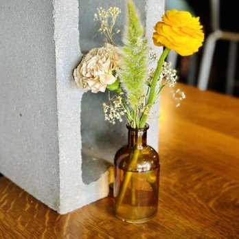 Chimera - a vase with flowers in it on a table - Coffee & Tea Near Me - Tulsa, Oklahoma