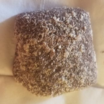 Candy Kitchen Shoppes - a closeup of a sugared donut - A square-shaped baked item with a textured, sugar-coated surface, possibly a pastry or bread, resting on a light-colored background. The surface appears crunchy and granular due to the sugar coating, with uneven texture and small bumps visible. - Candy Stores Near Me - Bethany Beach, Delaware