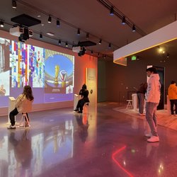 United States Olympic & Paralympic Museum - interactive room: learning about the olympics throughout the years (to the left) | screen to interviewing athletes (back left)