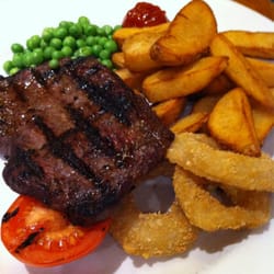 The Longhorn - Ribeye steak complete with potato wedges, onion rings and peas.